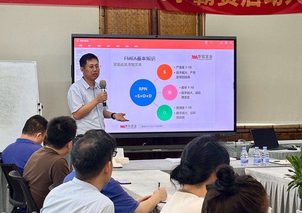 Small group discussing a manufacturing FMEA worksheet near a bolt forming machine