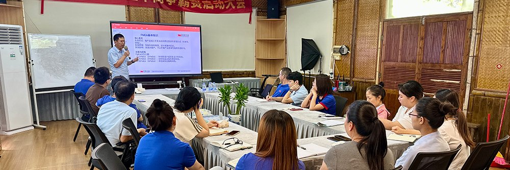 Trainer explaining FMEA form columns on a whiteboard with examples specific to fasteners